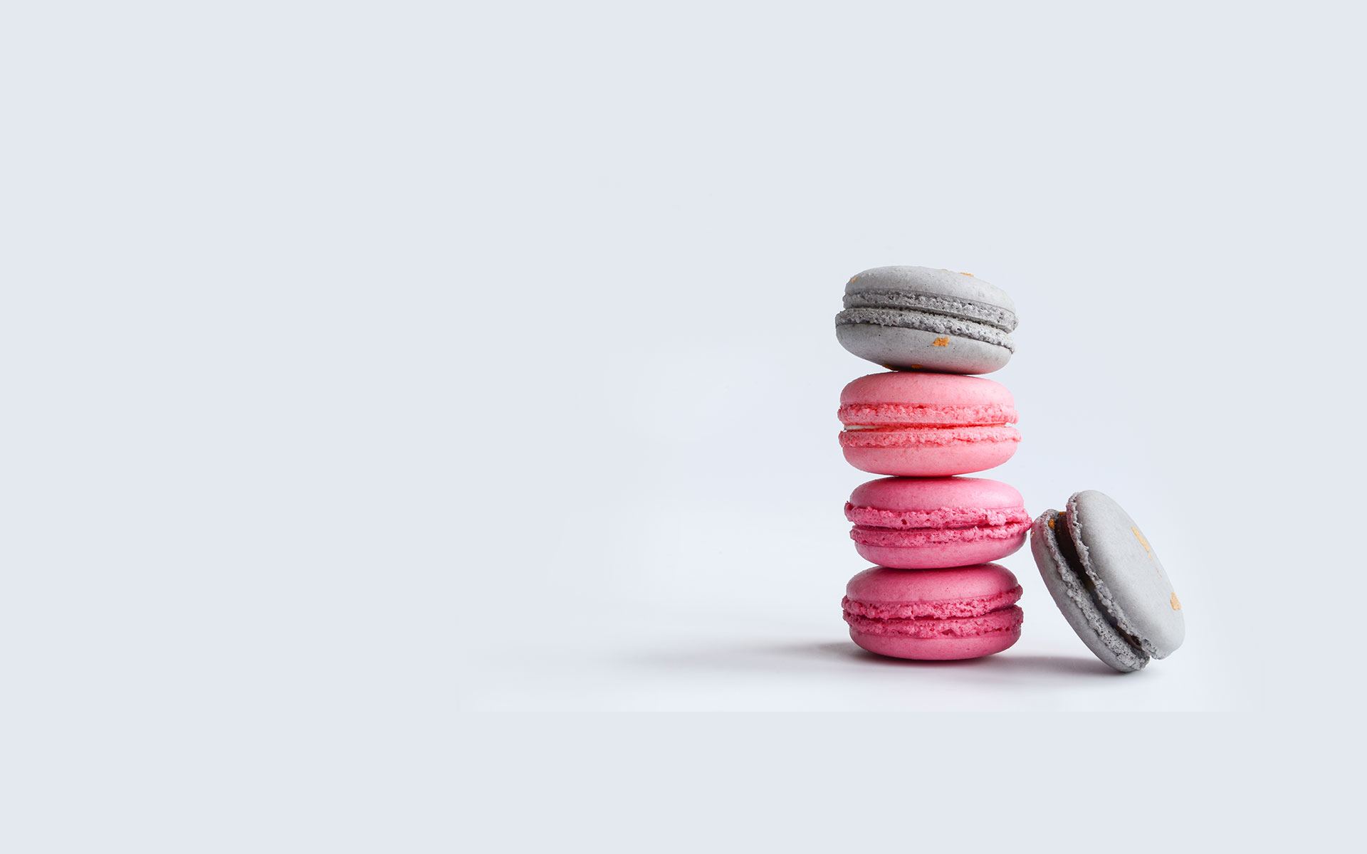 Stack of grey and pink macarons on a pale background